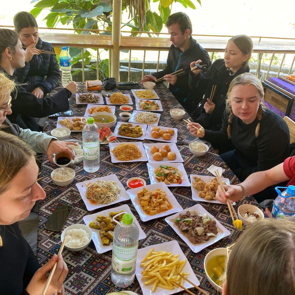 Travelers enjoying a massive and delicious family-style Vietnamese meal.